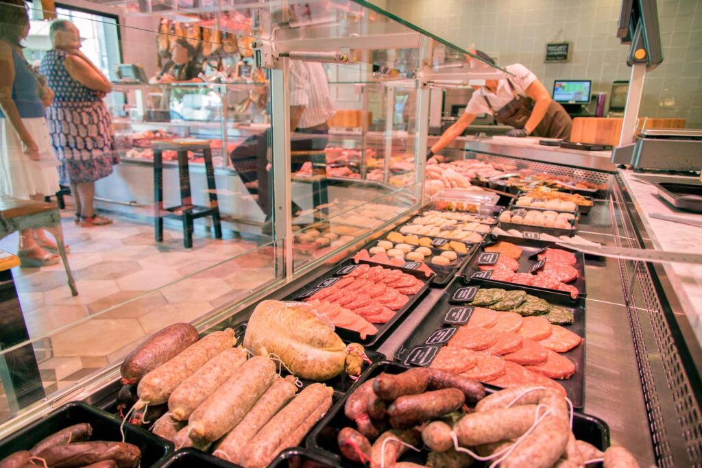 Interior de la Carnisseria Nogales on es veu l'aparador ple de productes càrnics.