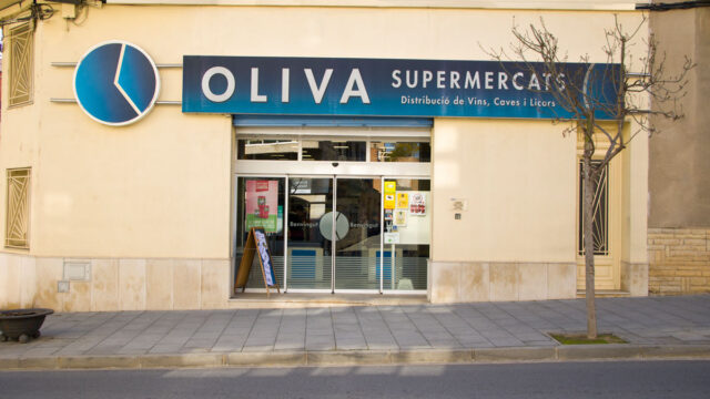 Fotografia des de l'exterior, de l'entrada al supermercat Oliva.