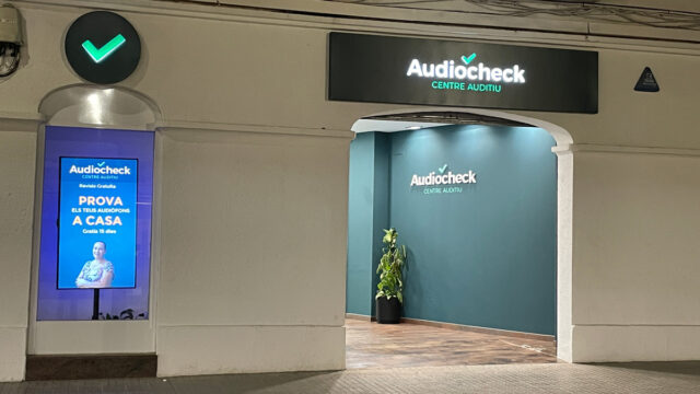 Entrada amb una paret pintada de color blau, on es veu el logotip Audiocheck, Centre Auditiu.